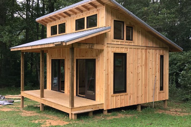Inspiration for a small rustic brown one-story wood exterior home remodel in Other with a shed roof and a metal roof