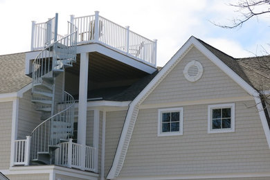 Inspiration for a large farmhouse beige two-story vinyl house exterior remodel in Bridgeport with a gambrel roof and a shingle roof