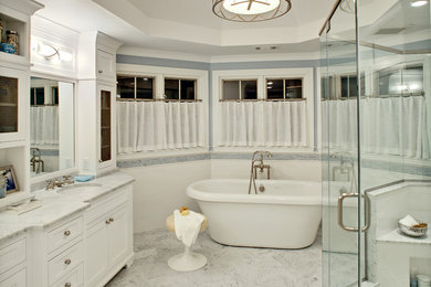 Photo of a mid-sized traditional master bathroom in New York with an undermount sink, a freestanding tub, a double shower, furniture-like cabinets, white cabinets, gray tile, stone tile, grey walls, marble floors, engineered quartz benchtops, multi-coloured floor and a hinged shower door.