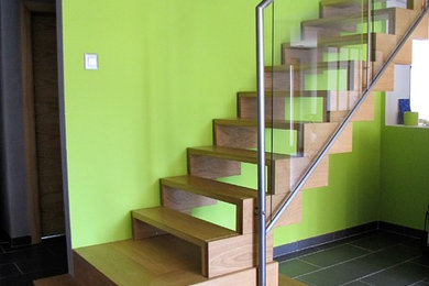 Photo of a mid-sized industrial wood straight staircase in Other with open risers and metal railing.