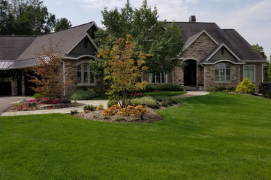 Design ideas for a huge mediterranean full sun hillside concrete paver retaining wall landscape in Grand Rapids for summer.