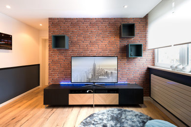 Inspiration pour un salon design avec un mur bleu, parquet clair, un téléviseur indépendant et du papier peint.