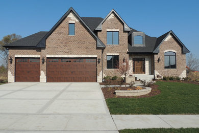 Large elegant brown two-story exterior home photo in Chicago