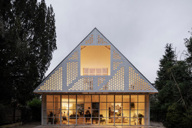 Imagen de fachada de casa blanca contemporánea de dos plantas con tejado a dos aguas