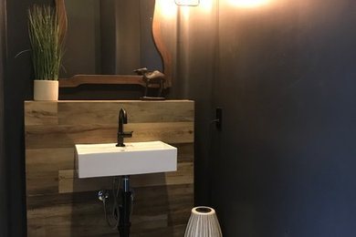 Example of a mid-sized transitional 3/4 cement tile floor and black floor bathroom design in Phoenix with distressed cabinets, black walls and a wall-mount sink