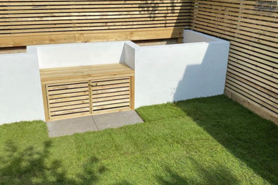 Inspiration for a small contemporary partial sun backyard stone and wood fence landscaping in Sussex for summer.
