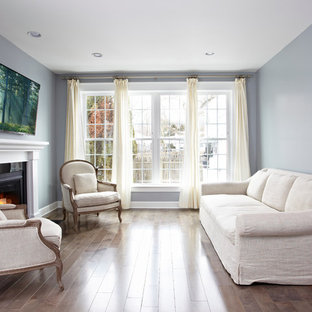 Inspiration för små moderna separata vardagsrum, med grå väggar, mellanmörkt trägolv, en standard öppen spis, en spiselkrans i trä och en väggmonterad TV