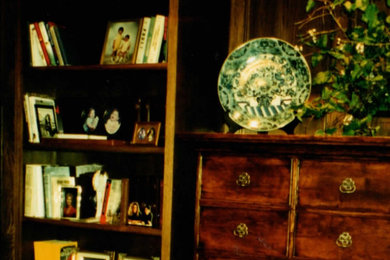 他の地域にある広いトラディショナルスタイルのおしゃれなホームオフィス・書斎 (ライブラリー、緑の壁、無垢フローリング、自立型机、茶色い床、羽目板の壁) の写真
