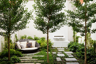 Inspiration for a mid-sized transitional backyard stone patio fountain remodel in New York with no cover