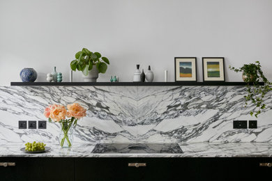 Inspiration for a large modern kitchen in London with flat-panel cabinets, black cabinets, marble worktops, multi-coloured splashback, marble splashback, an island and white worktops.