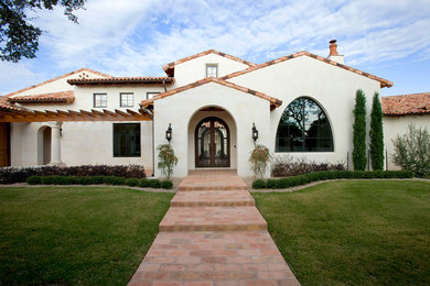 Mediterranean two-story stucco exterior home idea in Austin with a tile roof