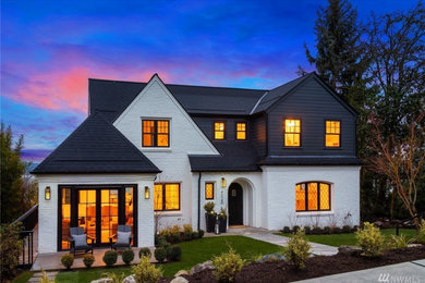 Inspiration for a large timeless white three-story brick and clapboard exterior home remodel in Seattle with a shingle roof and a black roof