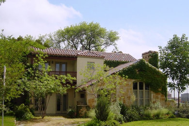 Photo of a mid-sized mediterranean two-storey exterior in Dallas with stone veneer.