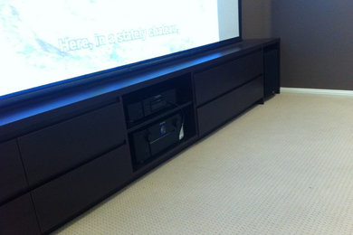 This is an example of a mid-sized modern home theatre in Sydney with a projector screen.