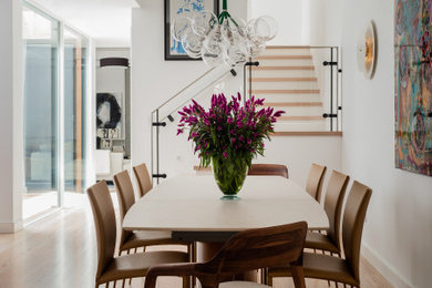 This is an example of a contemporary dining room in Boston with white walls, medium hardwood floors, no fireplace and brown floor.