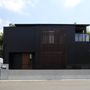 他の地域のモダンスタイルのおしゃれな住宅の外観 (黒い外壁、陸屋根) の写真