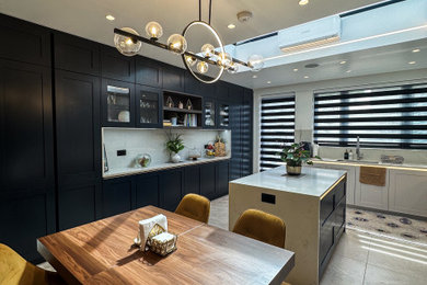 Inspiration for a large traditional l-shaped kitchen in London with a built-in sink, shaker cabinets, blue cabinets, quartz worktops, white splashback, engineered quartz splashback, integrated appliances, porcelain flooring, an island, beige floors, white worktops and feature lighting.