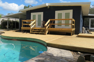 This is an example of a mid-sized contemporary backyard deck in Orlando with with dock and no cover.