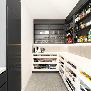 На фото: угловые кухни в современном стиле с кладовкой, открытыми фасадами, черными фасадами, фартуком из цементной плитки, серым полом и белой столешницей без острова