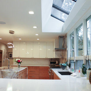 Idéer för ett stort modernt beige kök, med en undermonterad diskho, släta luckor, orange skåp, granitbänkskiva, vitt stänkskydd, rostfria vitvaror, klinkergolv i porslin, en köksö och vitt golv