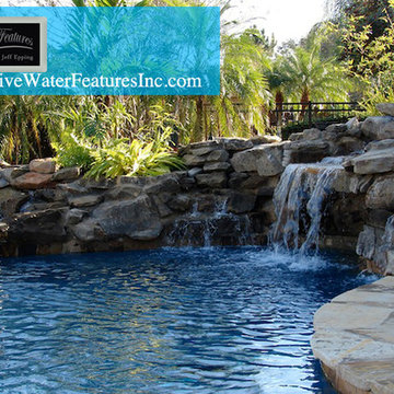 Tropical backyard room with pool waterfall, fireplace, and koi pond