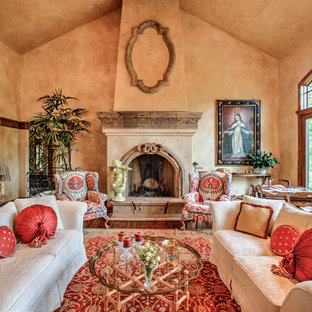 Imagen de salón para visitas cerrado, mediterráneo, grande, sin televisor, con paredes beige, suelo de madera en tonos medios, chimenea tradicional y marco de chimenea de piedra