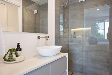 Design ideas for a contemporary bathroom in Gold Coast - Tweed with grey cabinets, an open shower, gray tile, ceramic tile, white walls, ceramic floors, a vessel sink, engineered quartz benchtops, grey floor, a hinged shower door and white benchtops.