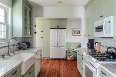 Enclosed kitchen - small traditional u-shaped medium tone wood floor enclosed kitchen idea in DC Metro with a farmhouse sink, recessed-panel cabinets, green cabinets, quartz countertops, white backsplash, ceramic backsplash, white appliances and no island