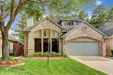 Large traditional multicolored one-story brick exterior home idea in Houston with a shingle roof