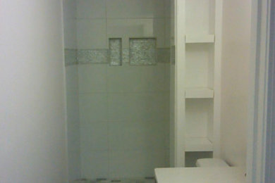 Bathroom - small traditional 3/4 white tile and porcelain tile dark wood floor and brown floor bathroom idea in Other with shaker cabinets, white cabinets, a one-piece toilet, white walls, an undermount sink, quartz countertops and white countertops
