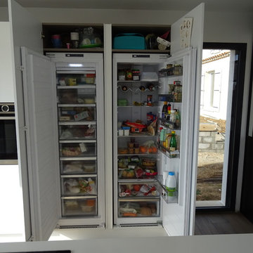 Cuisine moderne blanc laqué avec ilot central et mur de colonne