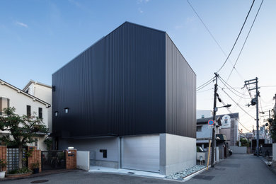 Example of a large black three-story metal and board and batten house exterior design in Other with a shed roof, a metal roof and a black roof