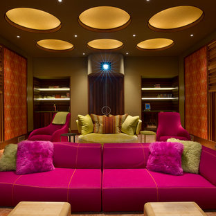 Réalisation d'une salle de cinéma design fermée avec un mur multicolore, moquette et un sol orange.