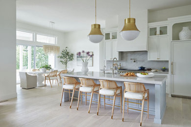 Example of a huge eclectic l-shaped light wood floor and brown floor eat-in kitchen design in Portland with a farmhouse sink, recessed-panel cabinets, white cabinets, quartzite countertops, multicolored backsplash, stone slab backsplash, paneled appliances, an island and multicolored countertops