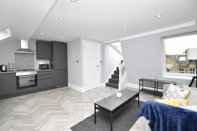 Medium sized contemporary open plan living room in London with blue walls, laminate floors and grey floors.