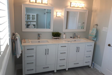 Example of a small minimalist master ceramic tile and gray floor bathroom design in Toronto with flat-panel cabinets, white cabinets, gray walls, an undermount sink and marble countertops