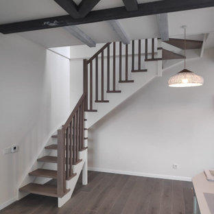 Ispirazione per una piccola scala a "L" con pedata in legno, parapetto in legno e pareti in mattoni