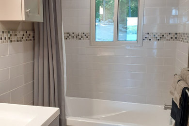 Small trendy master gray tile and ceramic tile vinyl floor, gray floor and single-sink bathroom photo in Other with shaker cabinets, gray cabinets, a one-piece toilet, gray walls, a drop-in sink, marble countertops, white countertops and a freestanding vanity