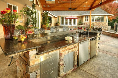 Inspiration for a mid-sized timeless backyard stamped concrete patio kitchen remodel in Houston with a roof extension