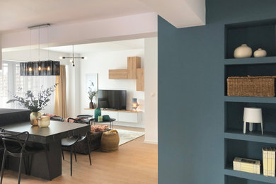 Ejemplo de salón tipo loft y blanco y madera moderno de tamaño medio con paredes azules, suelo laminado, televisor independiente y suelo beige