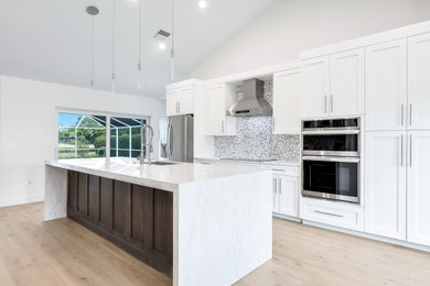 Example of a trendy single-wall porcelain tile, beige floor and vaulted ceiling open concept kitchen design in Other with shaker cabinets, white cabinets, stainless steel appliances, an island, an undermount sink, quartz countertops, multicolored backsplash, metal backsplash and white countertops