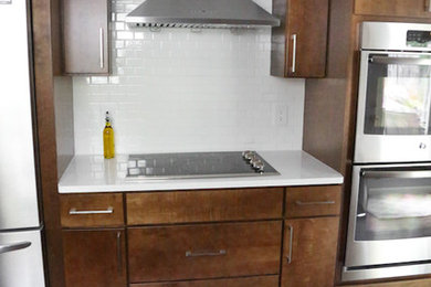 Inspiration for a transitional kitchen remodel in Other with a farmhouse sink, flat-panel cabinets, stainless steel appliances and an island