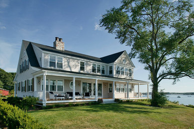 Inspiration for a large timeless beige two-story wood exterior home remodel in Boston with a hip roof