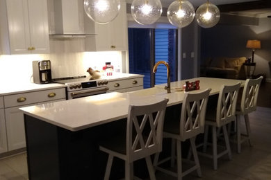 Inspiration for a contemporary ceramic tile and white floor kitchen remodel in Detroit with a farmhouse sink, recessed-panel cabinets, dark wood cabinets, quartz countertops, white backsplash, mosaic tile backsplash, white appliances and white countertops
