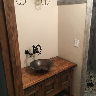 Inspiration for a rustic 3/4 brick floor bathroom remodel in Other with recessed-panel cabinets, dark wood cabinets, a vessel sink and wood countertops