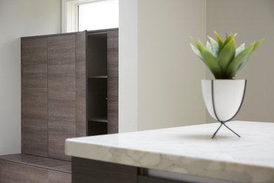 Huge minimalist u-shaped ceramic tile and white floor kitchen photo in Chicago with flat-panel cabinets, gray cabinets, marble countertops, stainless steel appliances and an island