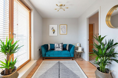Small modern formal enclosed living room in London with grey walls, laminate floors, no fireplace, a wall mounted tv and beige floors.