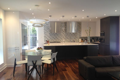 Example of a mid-sized minimalist l-shaped dark wood floor open concept kitchen design in Montreal with an undermount sink, flat-panel cabinets, gray cabinets, multicolored backsplash, an island and stainless steel appliances