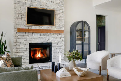 ナッシュビルにある広いトランジショナルスタイルのおしゃれなLDK (白い壁、濃色無垢フローリング、標準型暖炉、レンガの暖炉まわり、壁掛け型テレビ、茶色い床、表し梁) の写真