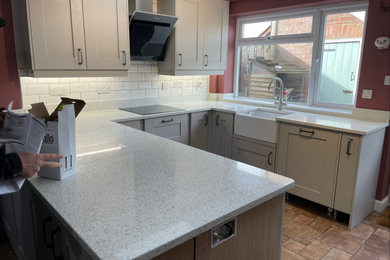 Photo of a country kitchen in Cambridgeshire with recycled glass countertops and white worktops.
